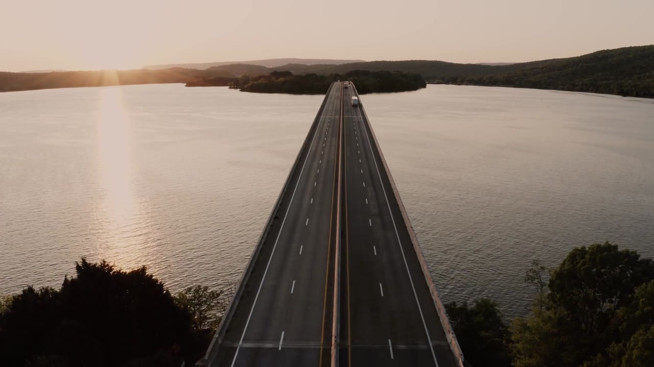 Aerial view of a truck crossing a bridge over water